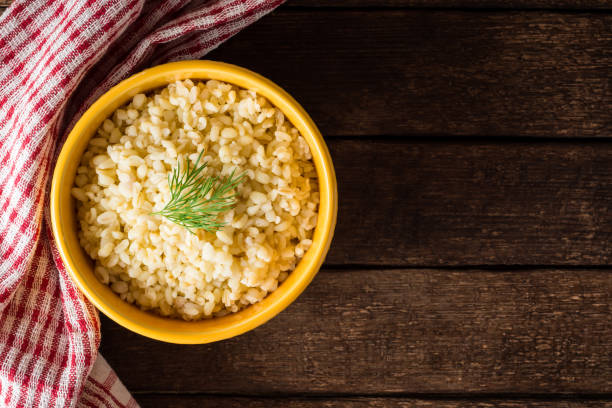 istock Bulgur with dill in yellow ceramic bowl on dark wooden background 834797756