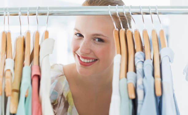 istock Happy female customer amid clothes rack 834800726