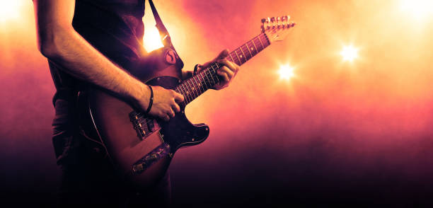 Guitarist playing a guitar, close-up Hand of a musician playing a guitar in backlit bass instrument photos stock pictures, royalty-free photos & images
