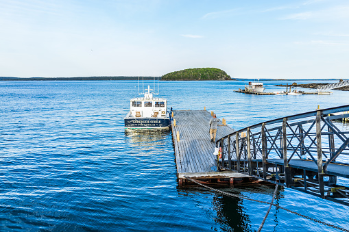 Bar Harbor: View of dock and boat with man in downtown village in summer