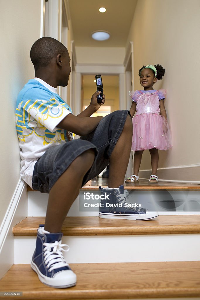 Boy taking cell phone picture of sister  12-13 Years Stock Photo