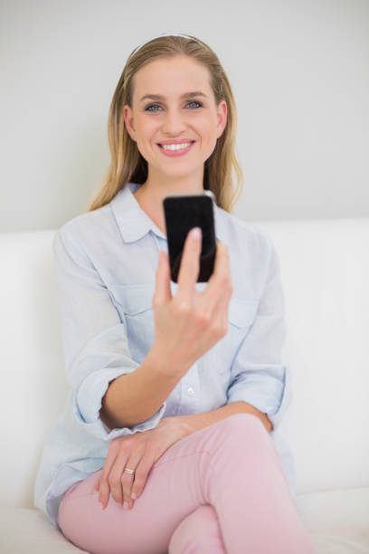 istock Smiling casual blonde holding smartphone 834837054