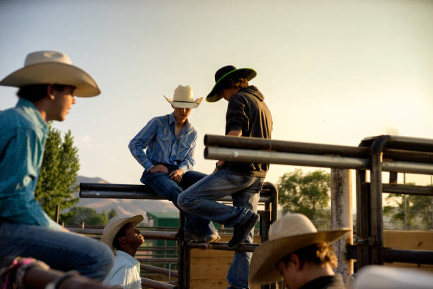istock Four Young Cowboys Conversing on a Fence 834841720