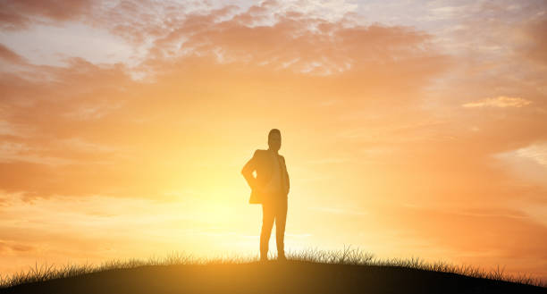 istock Businessman standing with sun light silhouette 834872296