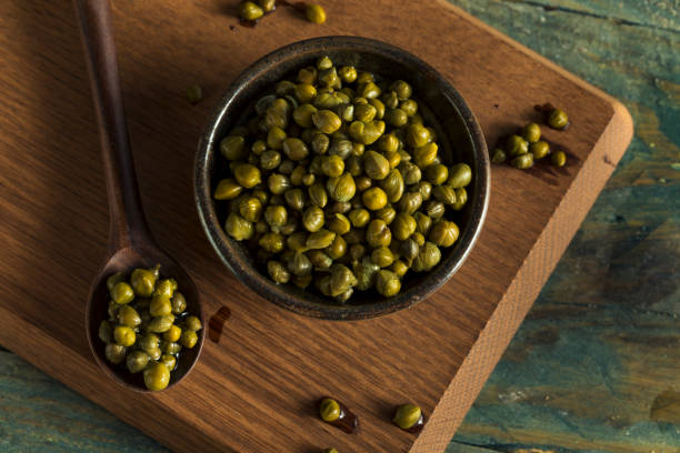 Raw Green Organic Marinated Capers Raw Green Organic Marinated Capers in a Bowl caper stock pictures, royalty-free photos & images