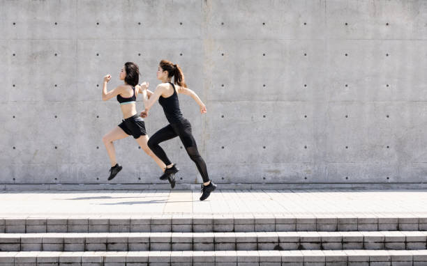 two asian ladies running outdoors - running women jogging profile imagens e fotografias de stock