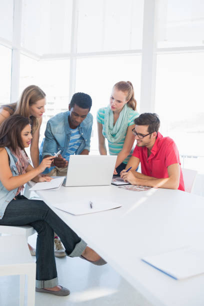 istock Young casual people using laptop in office 834883094