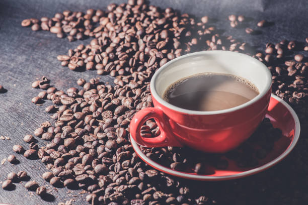 istock Hot coffee in red cup and coffee beans are the background. 834893818