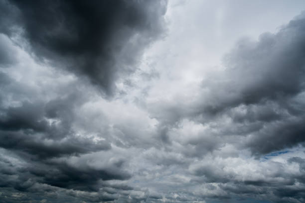 istock clouds with background,sunlight through very dark clouds background of dark storm clouds, black sky Background of dark clouds before a thunder. 834894760