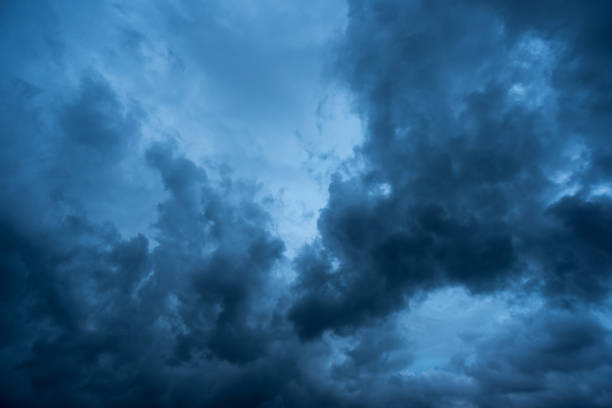 istock clouds with background,sunlight through very dark clouds background of dark storm clouds, black sky Background of dark clouds before a thunder. 834895074