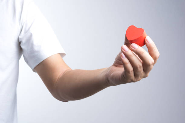 istock A man hand with wooden red heart object 834917480