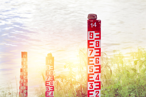 water level marker with numbers at a river in sunlight.