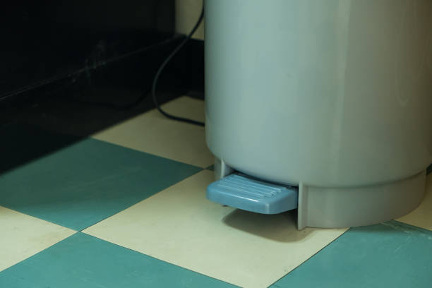 istock Gray plastic trash can with pedal on green floor pattern. 834923462