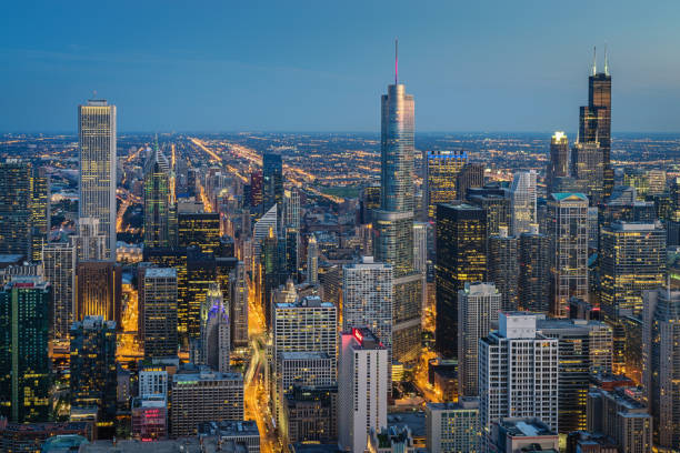 Chicago Skyline at Night Aerial View Aerial view of illuminated beautiful cityscape of downtown Chicago at night from above. Long time exposure. Motion blured traffic in the urban city streets. Chicago, Illinois, USA. aon center chicago photos stock pictures, royalty-free photos & images