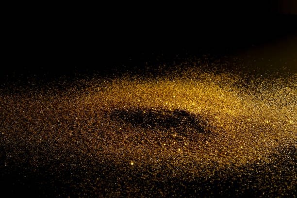 istock prinkle glitter gold dust on a black background with copy space 834994754