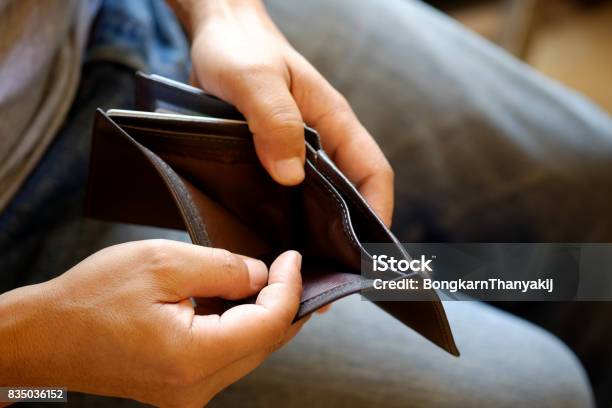 Man Looking At His Empty Leather Wallet In Office Stock Photo - Download Image Now - Poverty, Empty Wallet, Men