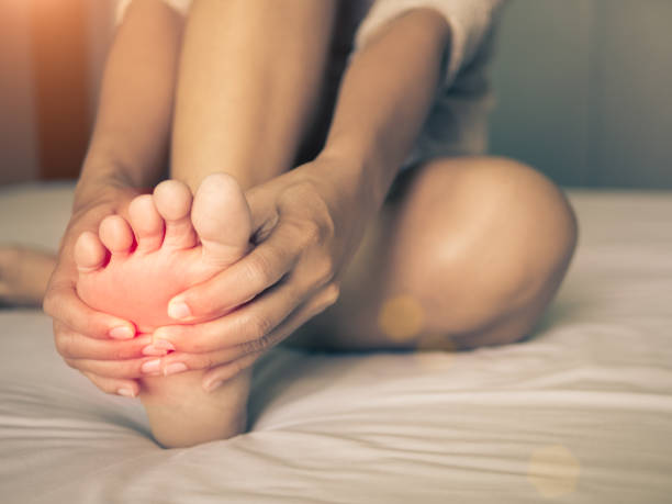 concepto de salud. mujer masajeando su pie doloroso, rojo hola iluminadas en el área del dolor - human pregnancy yoga exercising prenatal care fotografías e imágenes de stock