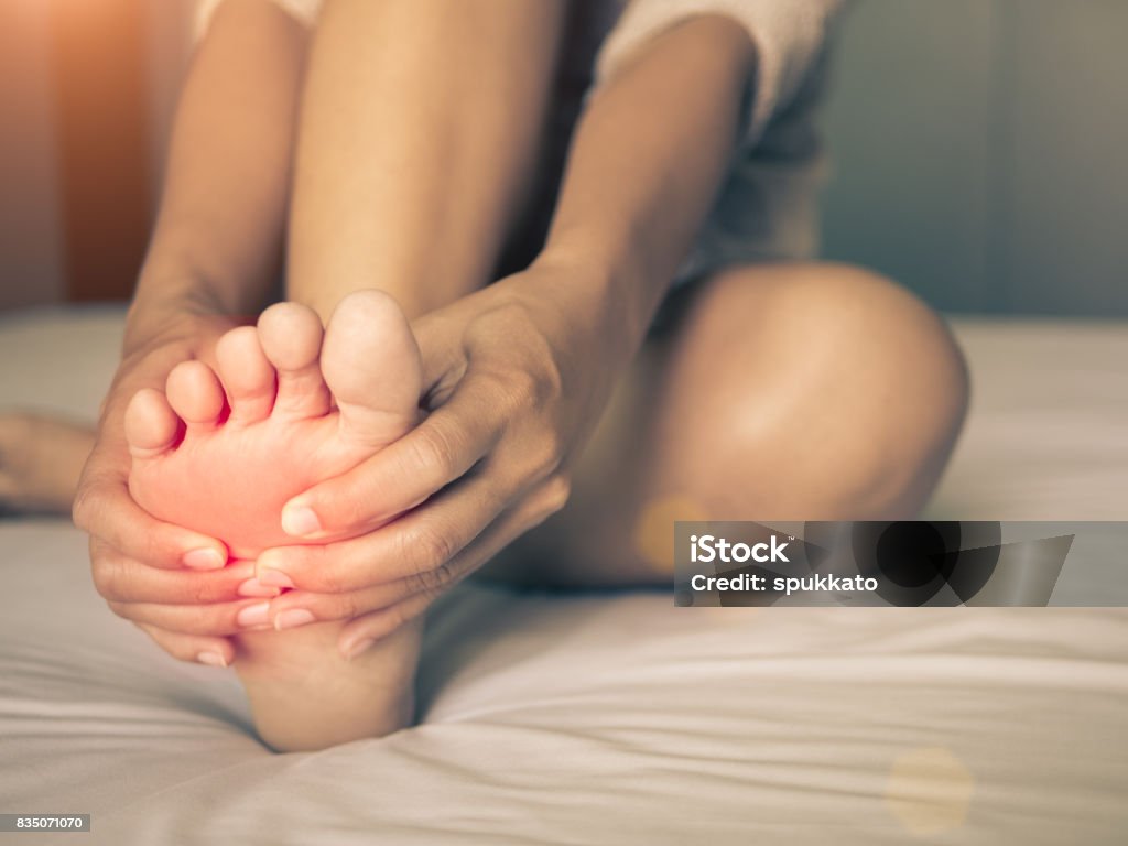 concept de soins de santé. femme masser son pied douloureux, rouge Salut éclairé sur la zone douloureuse - Photo de Pied libre de droits