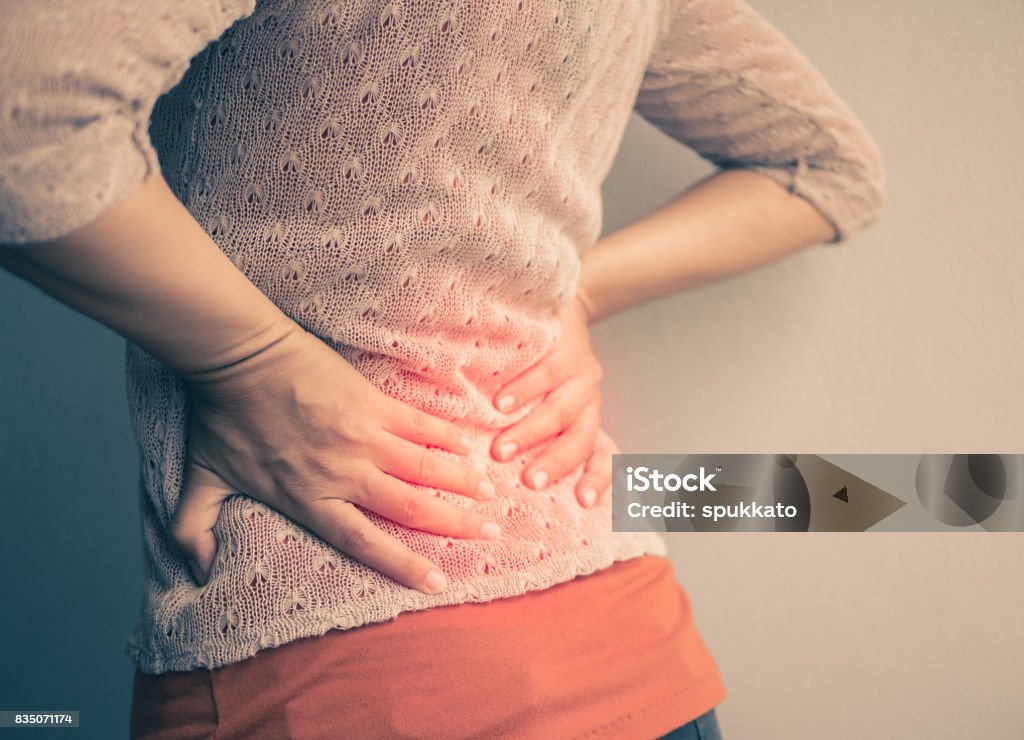 Closeup woman with hands holding her waist back in pain. Health-care Concept. Abdomen Stock Photo