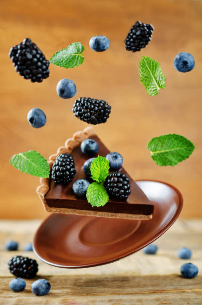 tarte au chocolat avec framboises et bleuets de vol - tart dessert chocolate fruit photos et images de collection