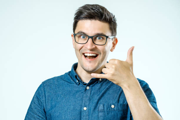 istock Call me! Handsome young man showing call me sign and smiling 835097094