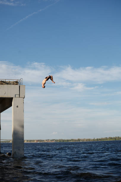 istock Man jumping into sea from pier 835136316