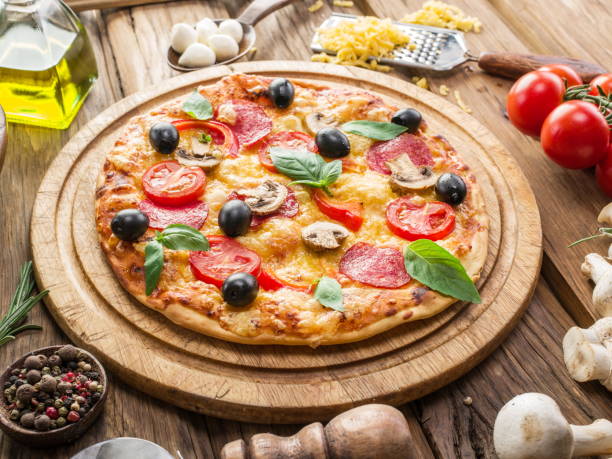 istock Pizza with mushrooms, salami and tomatoes. Top view. 835150376