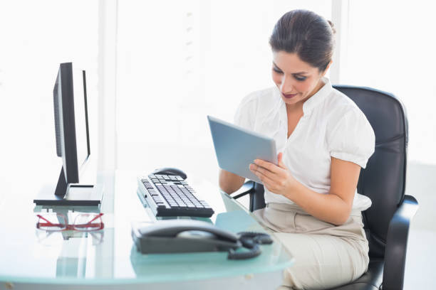 istock Smiling businesswoman using her digital tablet at desk 835151412