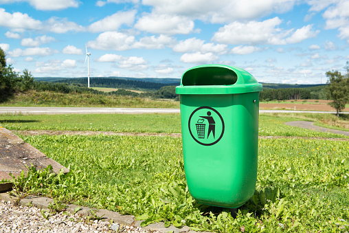 Green recycle bin outdoor with beautiful nature landscape, environment concept, rural road