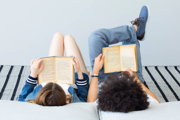 Young people reading book Young people reading book relaxation lying on back women enjoyment stock pictures, royalty-free photos & images