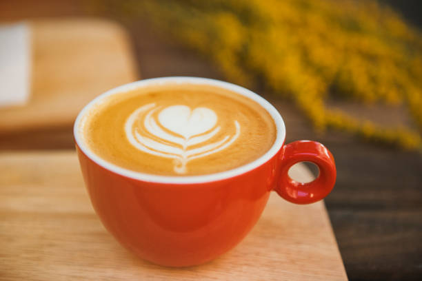 istock Red coffee cup in a summer day with flowers in background 835178516