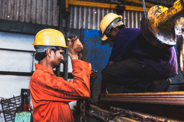istock Working together to get the stacked metal sheets on a chained hook 835196300