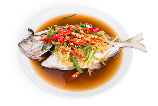 Steamed fish with soy sauce and ginger isolated on white background