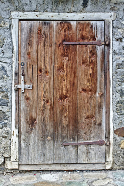 istock Old weathered wooden door with grey field stone wall 835203202