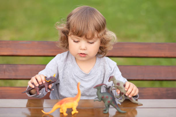 istock Toddler kid playing with a toy dinosaur 835203240