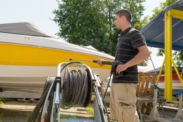 istock young man cleaning boat with high pressure water 835207358