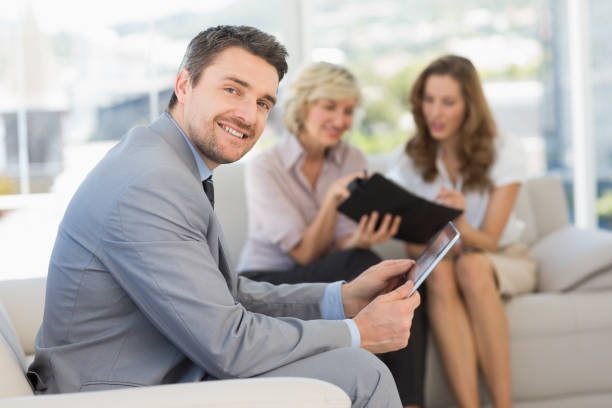 istock Businessman using digital tablet with colleagues at home 835210694