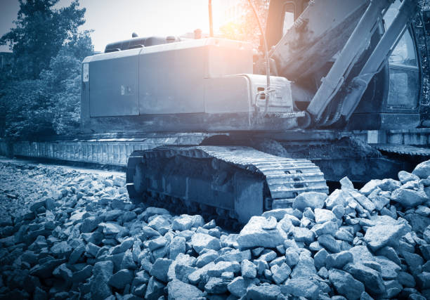 heavy organge excavator with shovel standing on hill with rocks