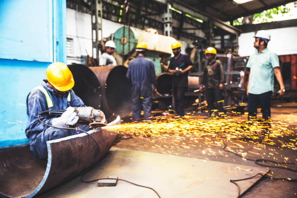 istock Metal grinder working in his corner as his co-workers do their own work 835261206