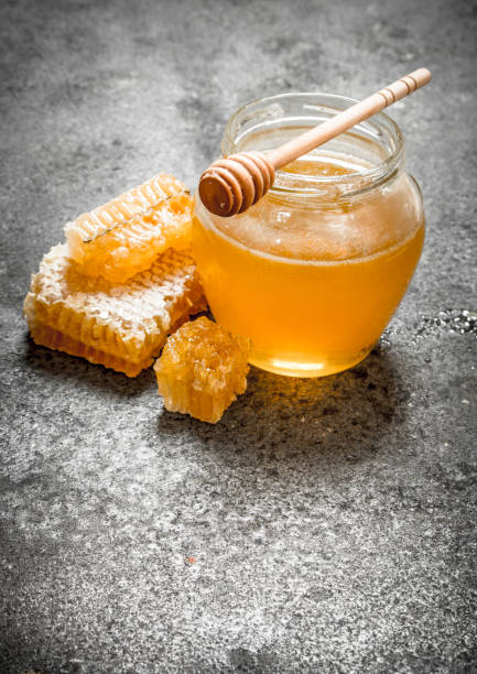 istock Fresh honey in jar with wooden spoon. 835261582