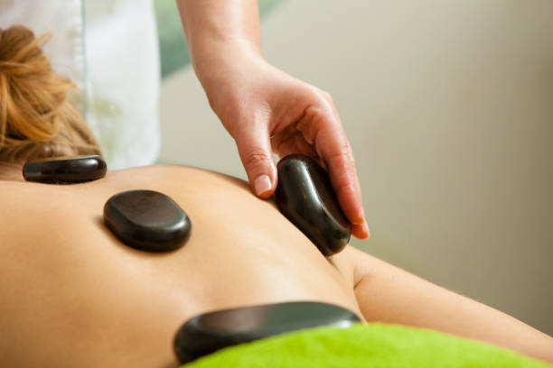 istock Massage with hot rocks stones in beautician 835277094