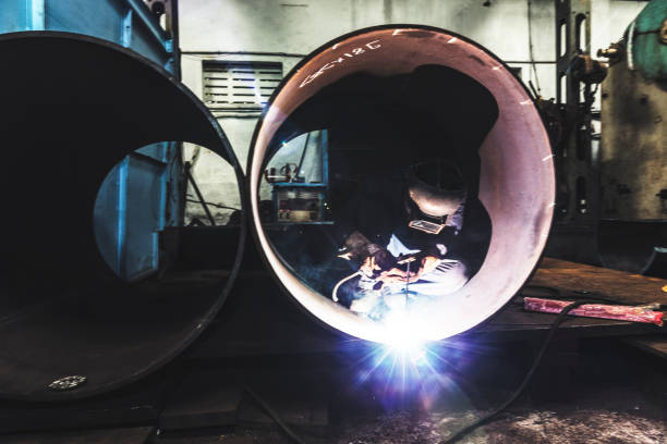 istock Welder working in a dark factory, being lit by a single light source 835285214