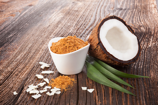 Coconut sugar and coconut on wooden table. Healthy sugar eating.