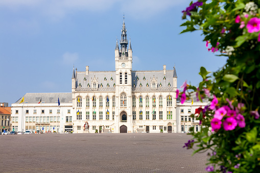 The market square and town hall of the Flemish town of Sint Niklaas in Belgium behind some flowers