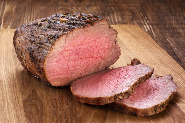 istock Baked meat on a wooden background. Roast beef. 835324544