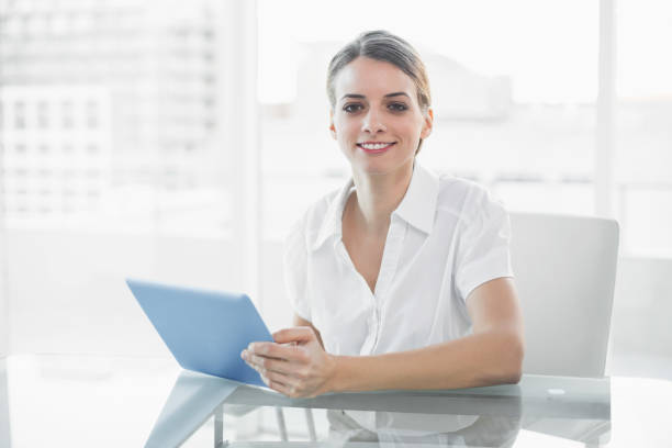 istock Gleeful smiling businesswoman working with her tablet looking at camera 835335464