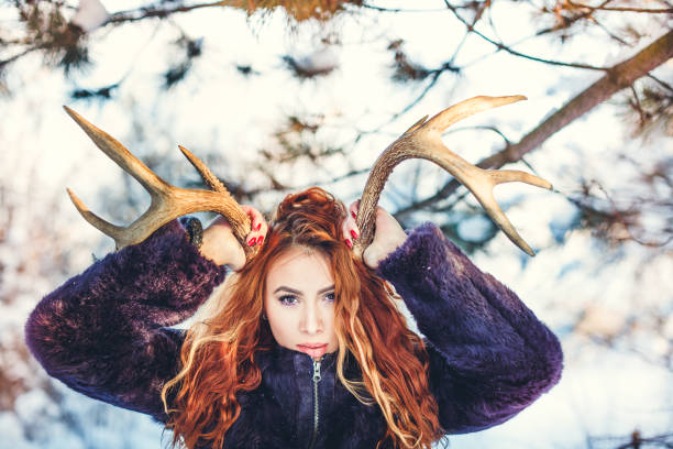 istock Redhead girl with deer horns on winter 835376164
