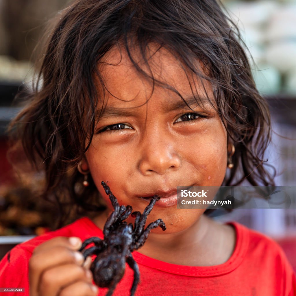 Cambodjaanse weinig meisje eten diepe gebakken tarantula, straatmarkt, Cambodja - Royalty-free Eten Stockfoto