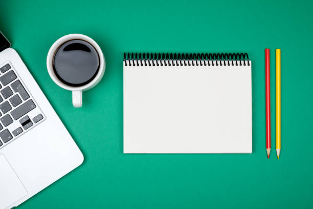 istock Modern green office desk table with laptop and blank notebook page for input the text. Top view, flat lay 835386540