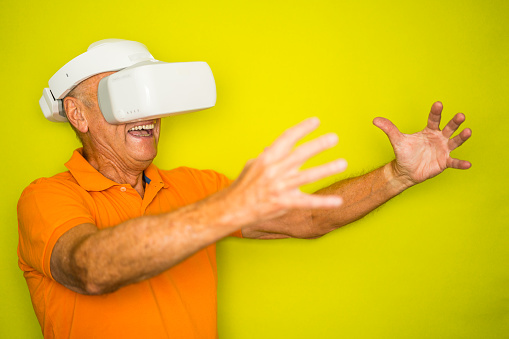Color Surge for Stylish Seniors - senior man with VR googles and outstretched arms